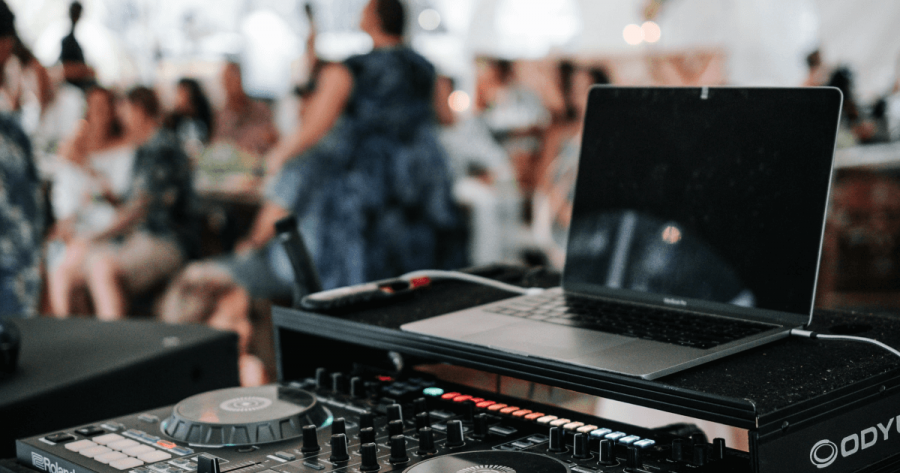 DJ-set with laptop and people in the background